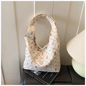 Detail of white textured fabric tote bag with colorful cartoon animal and heart prints