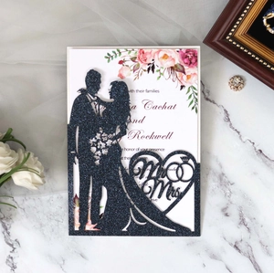 Detail showing laser-cut Mr & Mrs heart silhouette on glittery navy wedding invitation