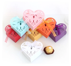 Laser cut heart shaped wedding favor boxes with ribbon and bird vine patterns
