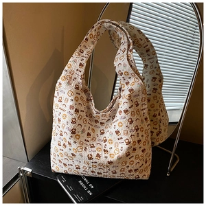 Detail of quilted white tote bag featuring cartoon bear patterns and sweet text embroidery