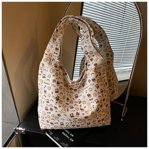 Detail of white canvas tote bag featuring cute cartoon bear and toast patterns with Sweet text