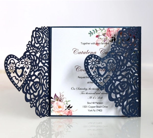 Detail of laser cut navy blue floral heart wedding invitation with white insert card