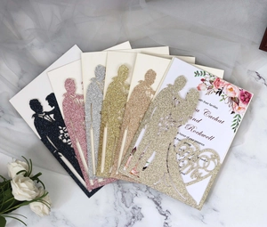 Laser-cut wedding invitations in glitter paper with romantic couple silhouette