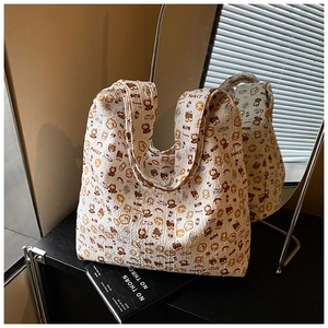 Detail of white quilted tote bag featuring cute cartoon bear and sweet toast patterns