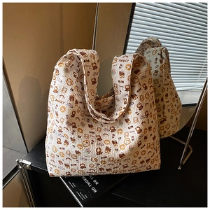 Detailed macro view of the wrinkled texture and cute bear print on this beige tote bag