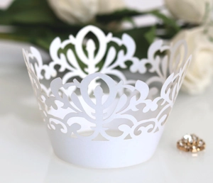 Close-up of laser-cut crown pattern white lace cupcake liners for wedding decoration