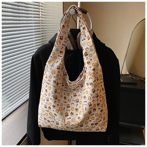 Detailed view of cream canvas tote bag featuring cute cartoon bear prints and wide straps