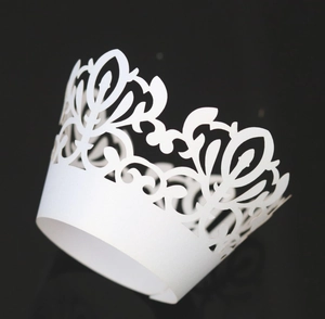 Detailed laser-cut pattern on white lace cupcake wrapper with elegant floral motifs