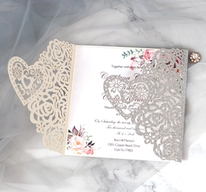Détail du faire-part de mariage découpé au laser avec fleurs beige et paillettes argent
