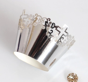 Macro detail of silver laser-cut cupcake wrapper with elegant hollow cross design