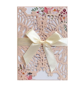 Laser cut light pink wedding invitation with floral insert and silk ribbon bow