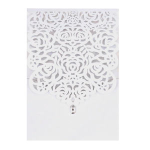 Macro view of laser-cut rose hollow pattern on white card with teardrop rhinestone