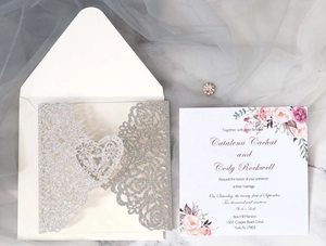 Détail de l'invitation de mariage en paillettes argentées découpées au laser avec roses