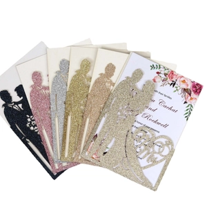 Glitter laser-cut wedding invitations with couple silhouette in gold, pink, and silver