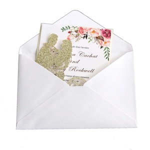 Glittery gold laser cut wedding invitation with floral card and white envelope