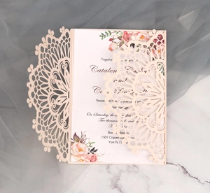 Detailed laser-cut light pink wedding invitation with floral inner card and mandala pattern