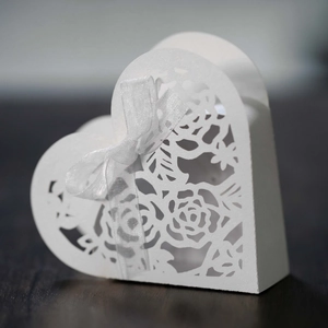Détail de boîte cadeau blanche découpée au laser avec ruban en soie pour dragées de mariage