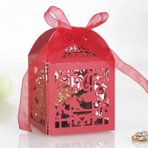 Detailed laser-cut heart pattern on a red gift box with matching organza ribbon bow