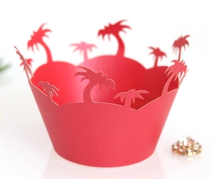Macro detail of laser-cut red cupcake wrapper featuring tropical palm tree silhouettes