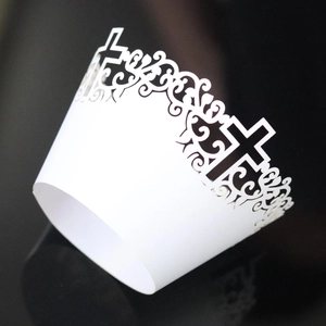 White laser-cut lace cupcake wrappers with intricate cross and floral hollow patterns