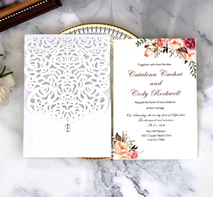 Detail of laser-cut rose hollow invitation with elegant watercolor floral inner card