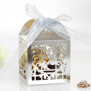 Detailed laser-cut silver favor box with birds motif and a light blue silk ribbon bow