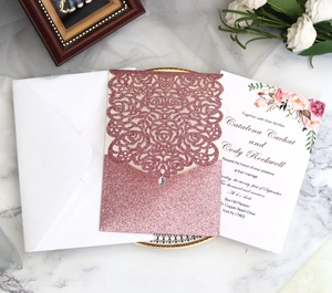 Προσκλητήριο γάμου laser-cut σε rose gold glitter με διαμάντι και φλοράλ λεπτομέρειες