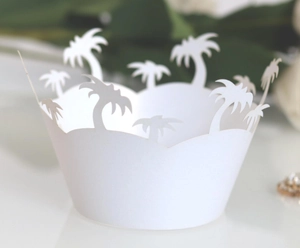 White laser-cut cupcake wrappers with tropical palm tree silhouettes for party decor