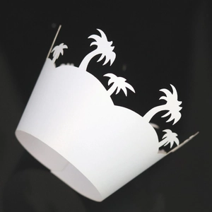 White laser-cut cupcake wrappers featuring tropical palm tree silhouettes for party decor