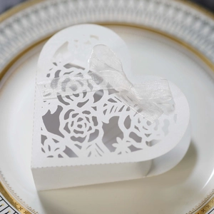 Détail boîte cadeau ajourée au laser avec motif de rose et ruban blanc élégant