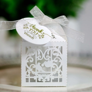 Detail of laser-cut wedding favor box with love birds, vine pattern and silver ribbon