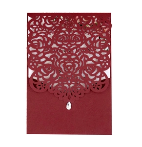 Detail of burgundy laser-cut rose wedding invitation with a teardrop diamond embellishment