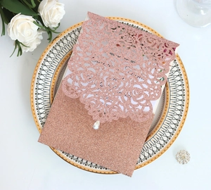 Λεπτομέρεια ροζ χρυσού προσκλητηρίου laser-cut με σχέδιο τριαντάφυλλο και μικρό κρύσταλλο