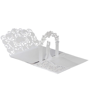 Detail of 3D laser cut white wedding invitation featuring a floral arch and couple silhouette