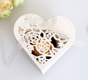 Détail du motif de rose découpé au laser sur boîte à bonbons de mariage en forme de cœur