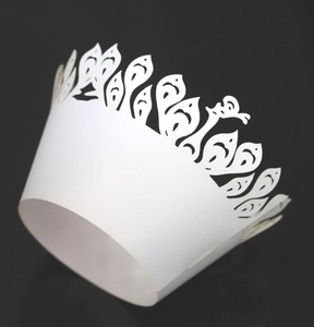 White laser cut cupcake wrappers with peacock patterns for wedding cake decorations