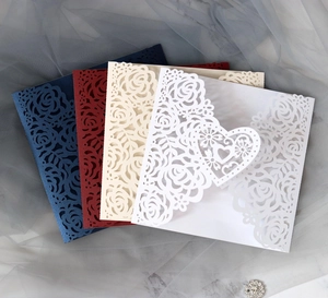 Detail of laser-cut rose patterns and heart clasp on multicolored pearlescent invitations