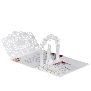 Detail of 3D laser-cut wedding invitation featuring a romantic silhouette under floral arch