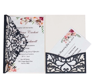 Detail of laser-cut navy glitter wedding invitation with elegant floral insert cards