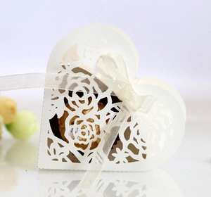 Détail de la boîte à bonbons ajourée avec ruban blanc et chocolats dorés brillants