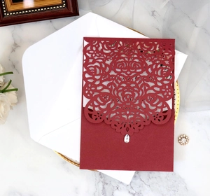 Detailed laser-cut rose floral invitation cover with rhinestone and matching envelope
