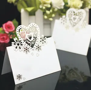 Macro detail of laser-cut lace heart design on white wedding place card stationery
