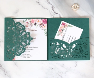 Detail view of laser-cut dark green wedding invitation set with elegant floral insert