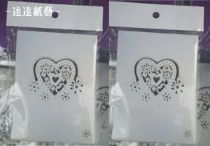 Detail showing white laser-cut seat cards with intricate floral heart lace patterns
