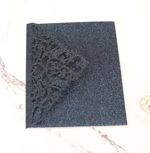 Detail view of laser-cut floral pattern on navy blue glitter tri-fold invitation
