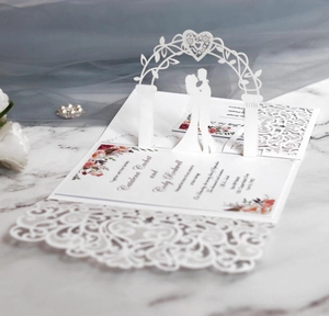 Detailed laser-cut 3D wedding invitation featuring elegant white heart and arch designs
