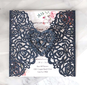 Vue détaillée de l'invitation découpée au laser avec paillettes bleues sur marbre blanc