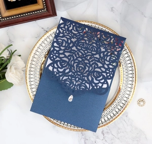 Detailed laser cut rose pattern on navy blue wedding invitation card with drop crystal