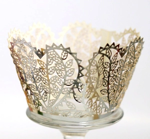 Elegant gold laser-cut cupcake wrappers with intricate leaf and vine patterns for weddings