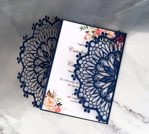 Detail of laser-cut navy blue wedding invitation with elegant pink floral inner sheet
